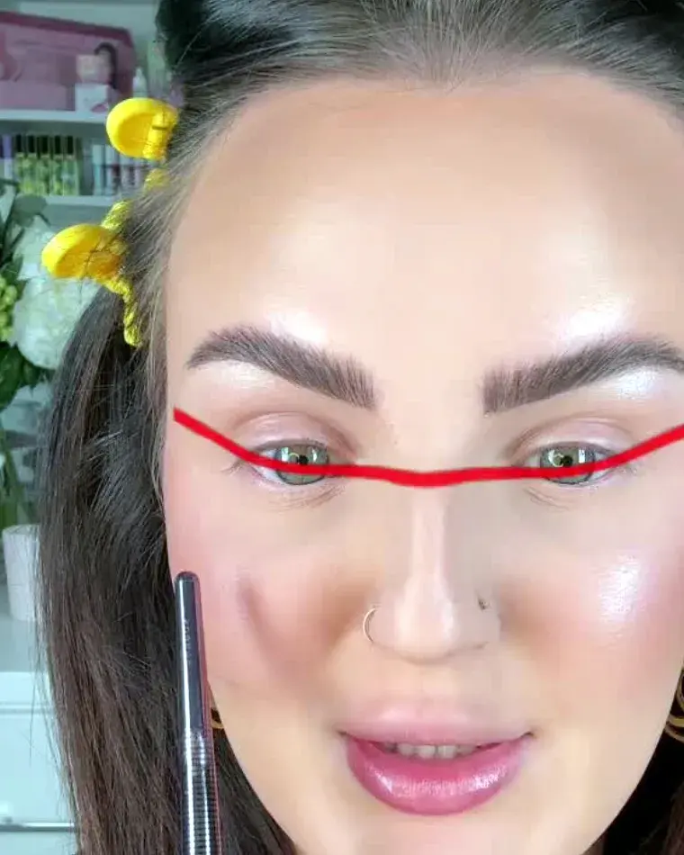 Beauty creator Mikayla Nogueira using the filter's red line as a guide for her eyeliner